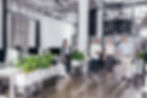 Multi-racial group of employees walking through the office in conversation