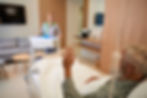 Senior patient waving at the incoming nurse bringing him lunch in his room