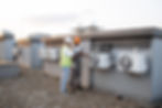 A professional IAQ assessment specialist accompanies the building maintenance team member to review cooling and ventilation systems