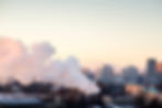 Cityscape view atop buildings with a thick concentration of smog in the foreground