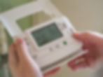 Image of a mans hands holding a thermostat